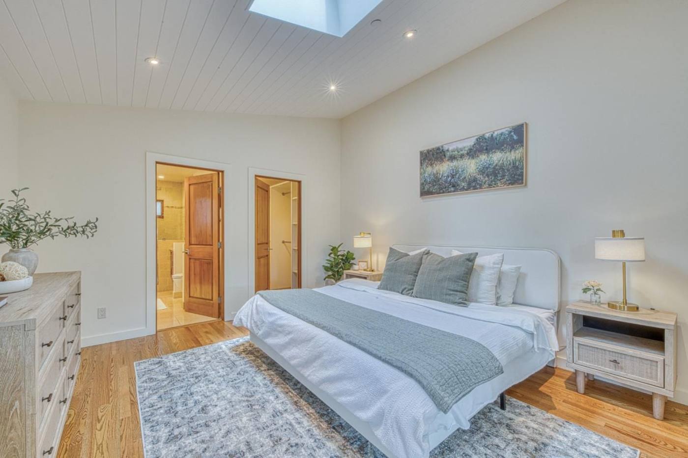 Staged primary bedroom with skylight