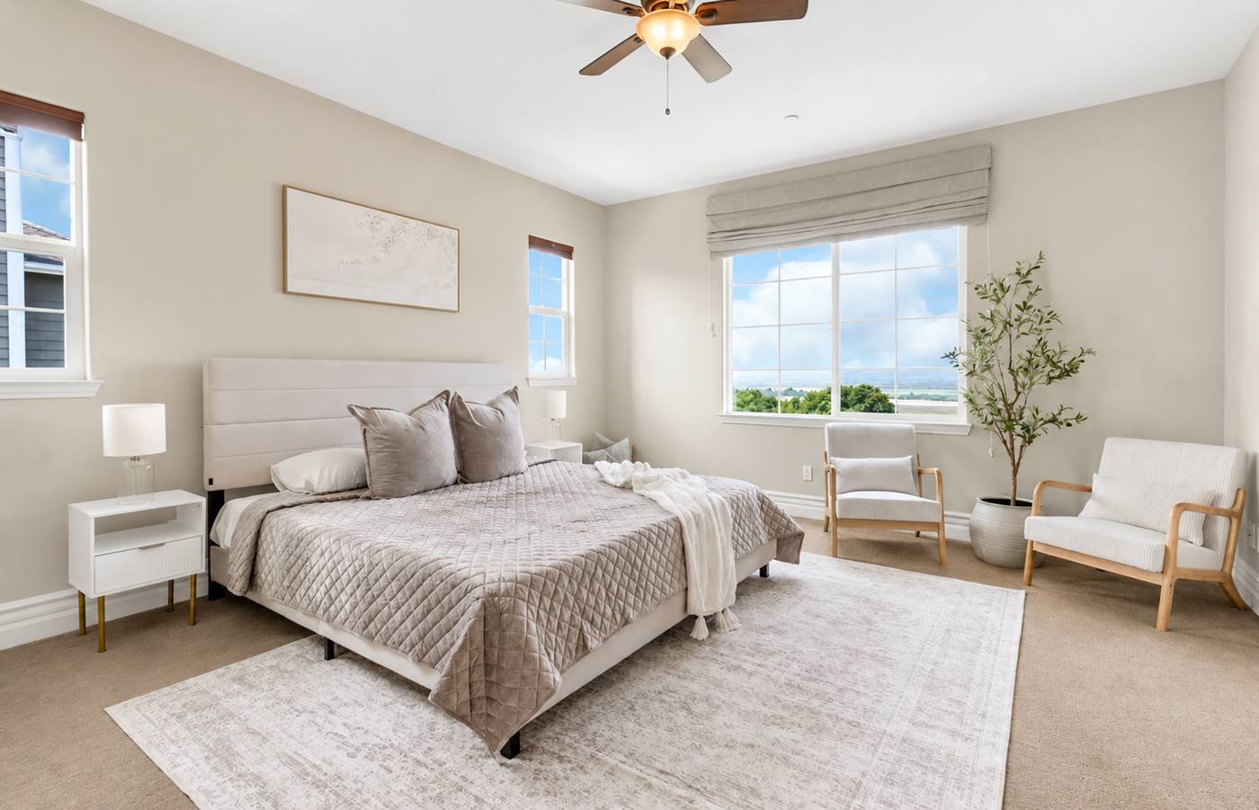 Staged primary bedroom with garden windows