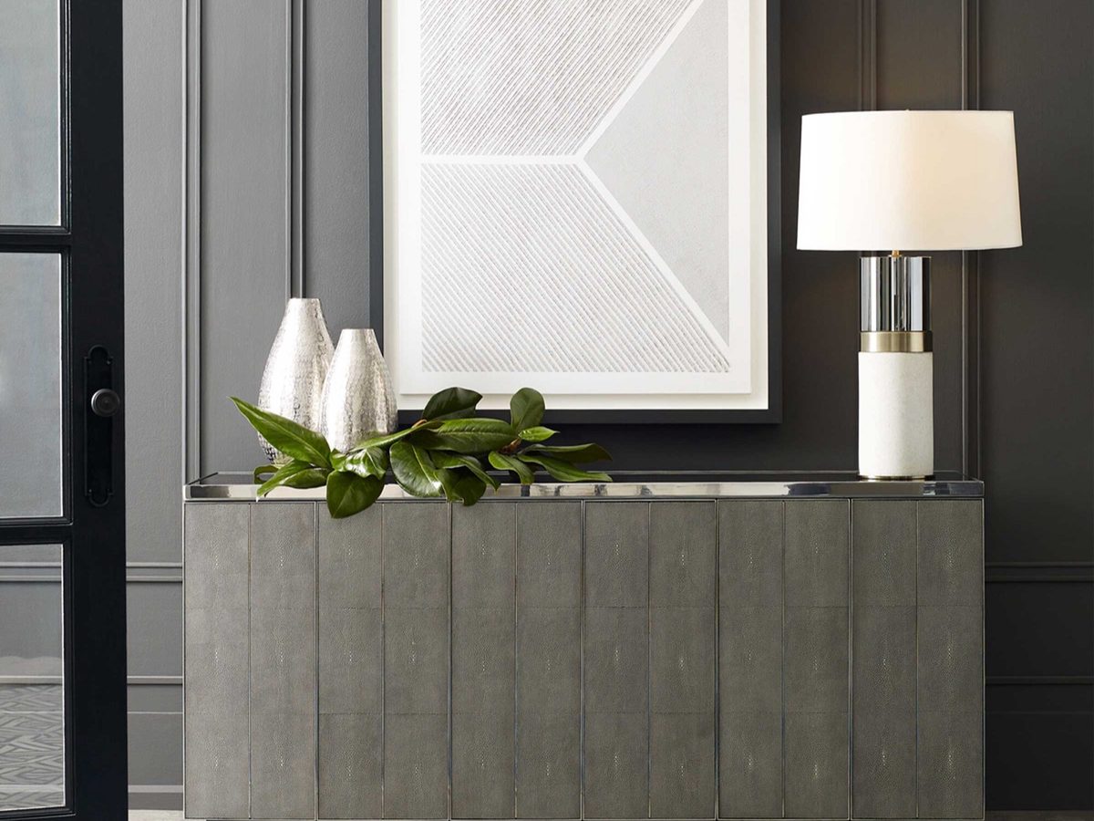 A Mitchell Gold + Bob Williams console styled against a dark panelled wall