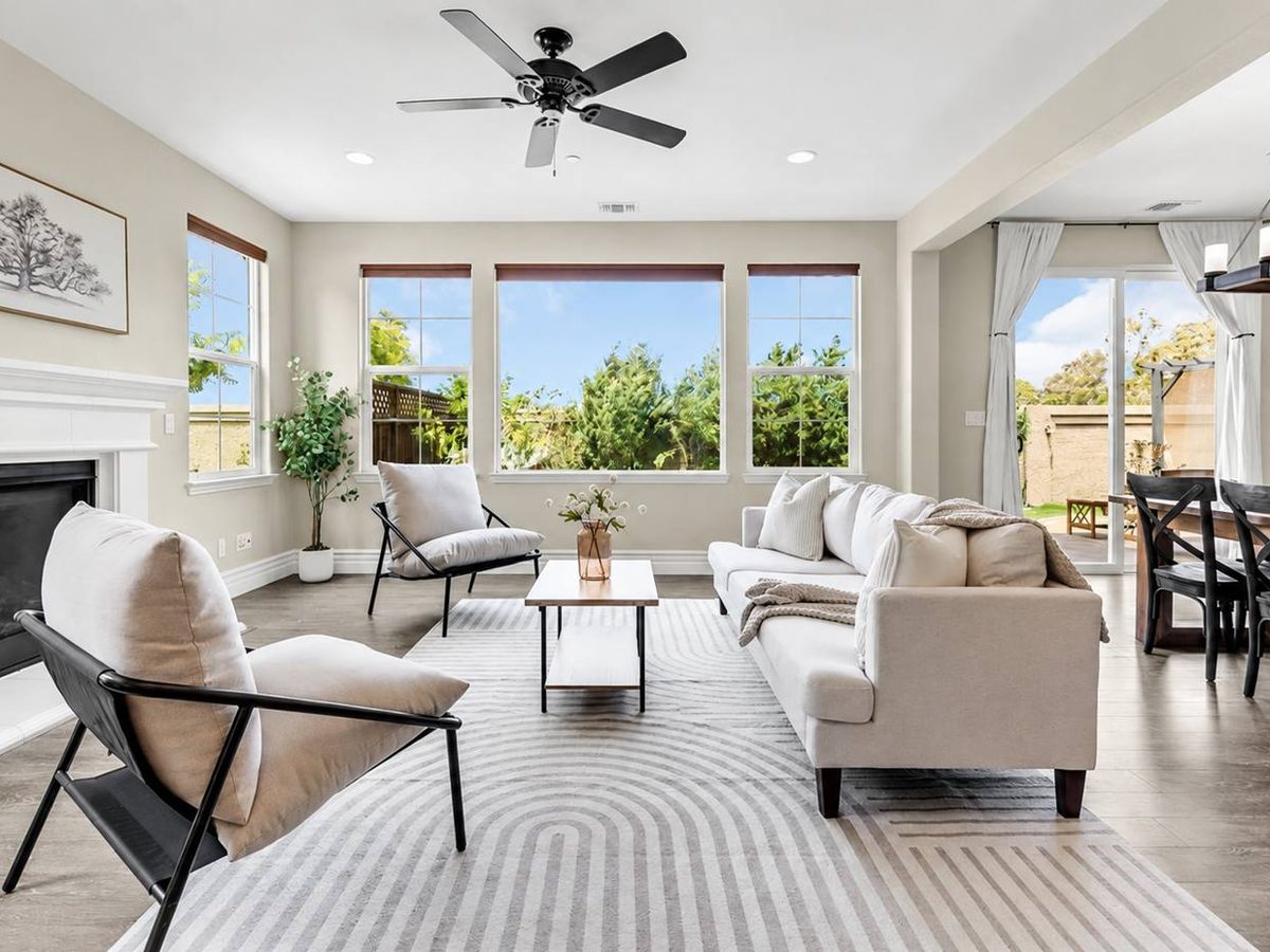 Living room staged by Salt & Cypress with a fireplace, sling chairs and a garden window wall