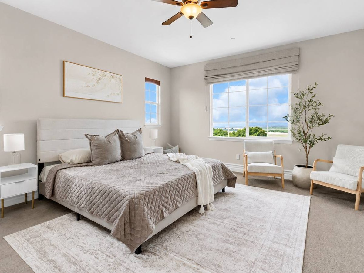 Primary bedroom staged by Salt & Cypress with layered bedding and garden windows