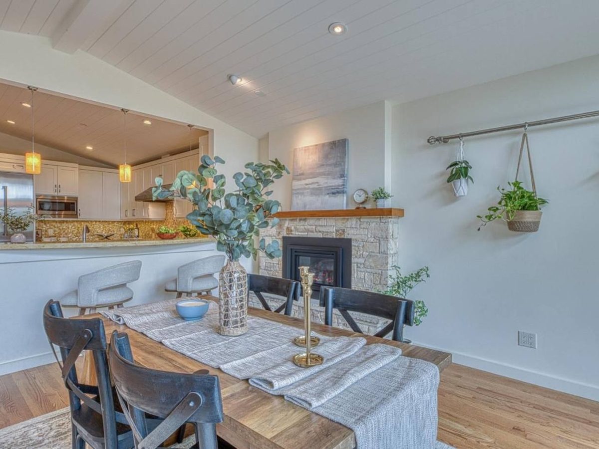 Dining room staged by Salt & Cypress beside a stone fireplace