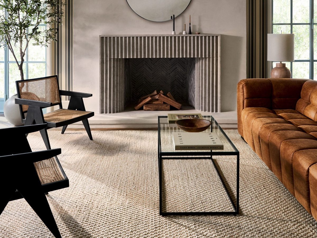 Living room with a fluted fireplace, leather sofa and a hand-knotted Surya rug